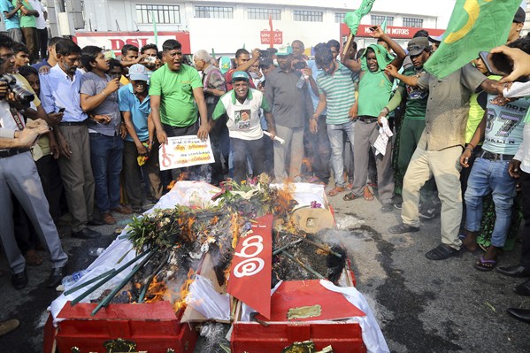 Supporters of the United National Party and ousted Prime Minister Ranil Wickremesinghe burn coffins to protest the government of disputed Prime Minister Mahinda Rajapaksa, Colombo, Sri Lanka, Nov. 15, 2018 (AP photo by Rukmal Gamage).
