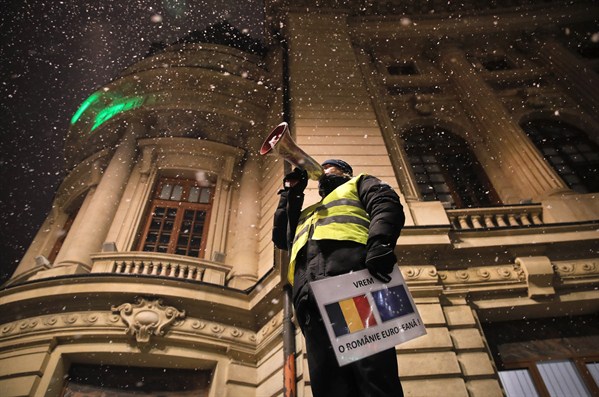 An anti-government protester holds a banner that reads “We want a European Romania” outside the Romanian Athenaeum concert hall, Bucharest, Jan. 10, 2019 (AP photo by Vadim Ghirda).
