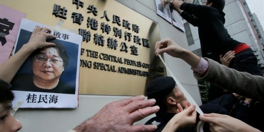 Protesters try to stick photos of missing booksellers, one of which shows Gui Minhai, during a protest outside the Liaison of the Central People’s Government in Hong Kong, Jan. 3, 2016 (AP photo by Vincent Yu).