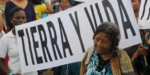 A woman attends a march to promote a law backed by then-President Juan Manuel Santos concerning the restitution of land to victims of the country’s armed conflict, Necocli, Colombia, Feb. 11, 2012 (AP photo by Luis Benevides).