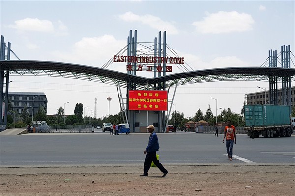 People walk past the gate of the Eastern Industrial Zone where Chinese company Huajian opened its first factory in Ethiopia in the town of Dukem near the capital, Addis Ababa, March 21, 2018 (AP photo by Elias Meseret).