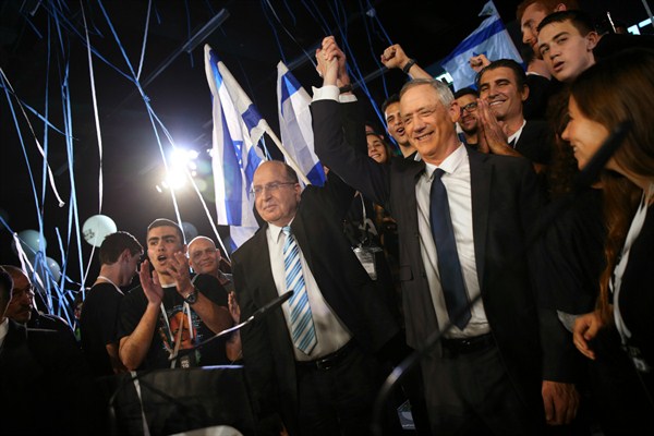 Retired Israeli military chief Benny Gantz, right, raises hands with former Defense Minister Moshe Ya’alon during the official launch of Gantz’s election campaign in Tel Aviv, Israel, Jan. 29, 2019 (AP photo by Oded Balilty).