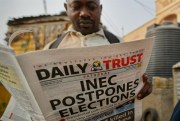 A man reads a copy of a newspaper leading with the news that the general election was postponed, Kano, northern Nigeria, Feb. 16, 2019 (AP photo by Ben Curtis).