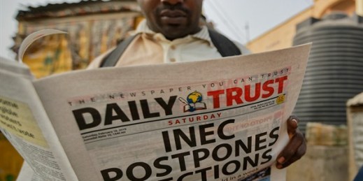 A man reads a copy of a newspaper leading with the news that the general election was postponed, Kano, northern Nigeria, Feb. 16, 2019 (AP photo by Ben Curtis).