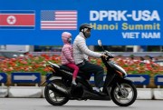 Traffic in Hanoi passes in front of a signboard announcing the upcoming summit between U.S. President Donald Trump and North Korean leader Kim Jong Un in Hanoi, Vietnam, Feb. 23, 2019 (Kyodo photo via AP Images).