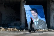 A man walks past a portrait of Syrian President Bashar al-Assad, Aleppo, Syria, Dec. 24, 2018 (Photo by Mikhail Voskresenskiy for Sputnik via AP).