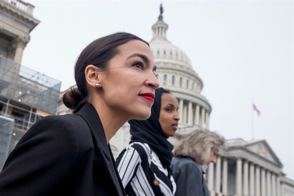 Rep. Alexandria Ocasio-Cortez, left, and Rep. Ilhan Omar, center, walk down the House steps to take a group photograph of the House Democratic women members of the 116th Congress, Washington, Jan. 4, 2019 (AP photo by Andrew Harnik).