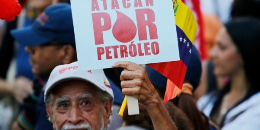 A man holds a sign that reads in Spanish “They attack for oil” during a march in support of the state-run oil company PDVSA, in Caracas, Venezuela, Jan. 31, 2019 (AP photo by Ariana Cubillos).