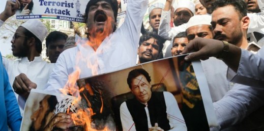 Indian Muslims burn posters of Pakistani Prime Minister Imran Khan, center, and Jaish-e-Mohammed leader Masood Azhar, during a protest in Mumbai, India, Feb. 15, 2019 (AP photo by Rajanish Kakade).
