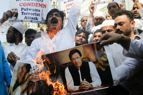 Indian Muslims burn posters of Pakistani Prime Minister Imran Khan, center, and Jaish-e-Mohammed leader Masood Azhar, during a protest in Mumbai, India, Feb. 15, 2019 (AP photo by Rajanish Kakade).