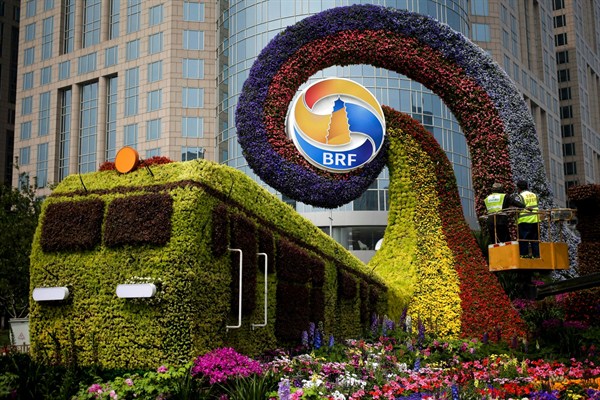 Workers install flowers on a decoration promoting the upcoming Belt and Road Forum in Beijing, April 23, 2019 (AP photo by Andy Wong).