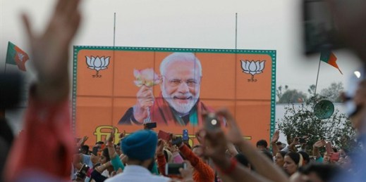 Bharatiya Janata Party supporters cheer by a giant billboard of Indian Prime Minister Narendra Modi during an election rally at Dumi village in Akhnoor, India, March 28, 2019 (AP photo by Channi Anand).