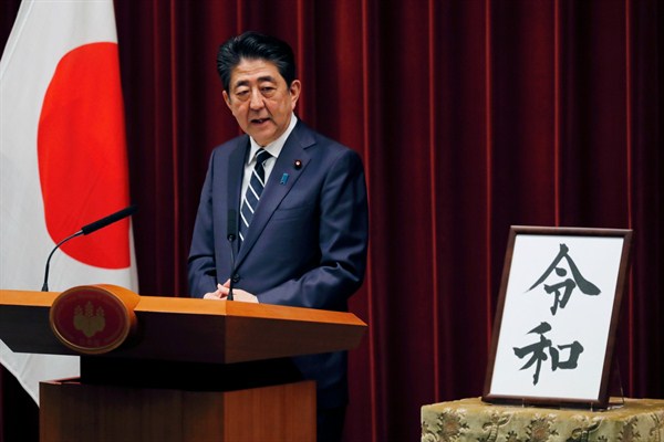 Japanese Prime Minister Shinzo Abe speaks alongside a placard showing the name of Japan’s new era, “Reiwa,” at the prime minister’s office in Tokyo, April 1, 2019 (AP photo by Eugene Hoshiko).