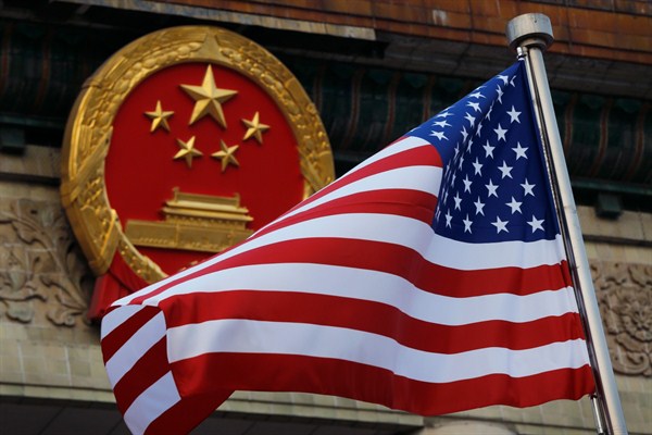 An American flag is flown next to the Chinese national emblem during a welcome ceremony for visiting U.S. President Donald Trump outside the Great Hall of the People in Beijing, Nov. 9, 2017 (AP photo by Andy Wong).