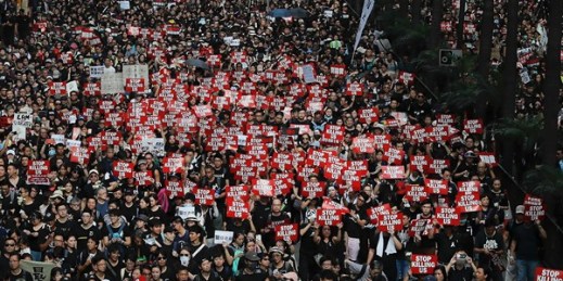 Tens of thousands of protesters carry posters and banners through the streets as they demonstrate against an extradition bill, in Hong Kong, June 16, 2019 (AP photo by Kin Cheung).