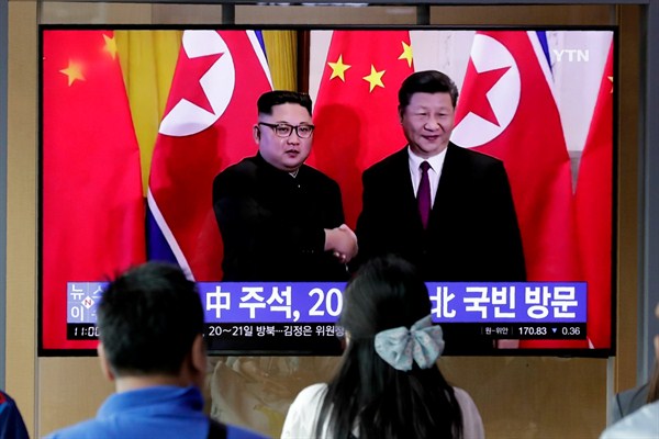 A TV news program reports on Chinese President Xi Jinping’s state visit to North Korea with file footage of Xi and North Korean leader Kim Jong Un, at the Seoul Railway Station in Seoul, South Korea, June 18, 2019 (AP photo by Lee Jin-man).