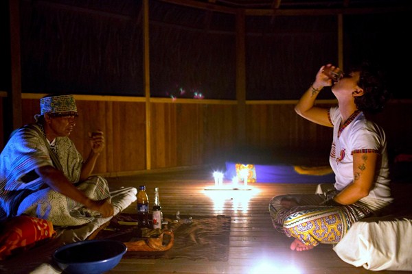An Italian tourist drinks ayahuasca, monitored by a shaman, during a session in Nuevo Egipto, a remote village in the Peruvian Amazon, May 6, 2018 (AP photo by Martin Mejia).