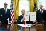 President Donald Trump holds up a signed executive order to increase sanctions on Iran, in the Oval Office of the White House, Washington, June 24, 2019 (AP photo by Alex Brandon).