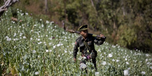 A Taang National Liberation army officer walking through a poppy field.