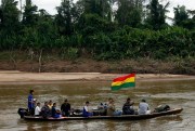 People, one carrying a Bolivian flag, in a boat at the Isiboro river, on the outskirts of San Miguelito, part of the Tipnis reserve, Bolivia, July 29, 2012 (AP photo by Juan Karita).