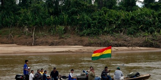People, one carrying a Bolivian flag, in a boat at the Isiboro river, on the outskirts of San Miguelito, part of the Tipnis reserve, Bolivia, July 29, 2012 (AP photo by Juan Karita).