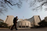 A man walks past China’s central bank, or the People’s Bank of China, in Beijing, March 10, 2019 (AP photo by Andy Wong).
