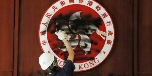 A protester defaces the Hong Kong emblem after breaking in to the Legislative Council building in Hong Kong, July 1, 2019 (AP photo by Kin Cheung).