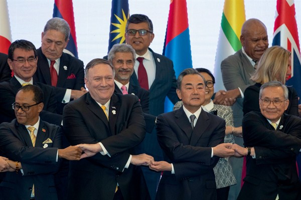 U.S. Secretary of State Mike Pompeo, center left, and Chinese Foreign Minister Wang Yi, center right, cross their arms with the other representatives during the ASEAN Regional Forum in Bangkok, Thailand, Aug. 2, 2019 (AP photo by Gemunu Amarasinghe).