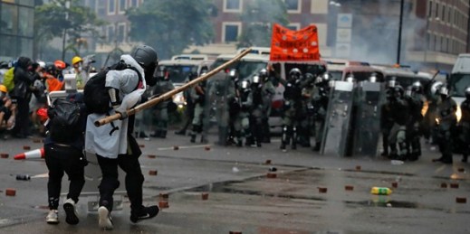 Protesters use bamboo sticks as they face riot police during a protest in Hong Kong, Aug. 25, 2019 (AP photo by Kin Cheung).