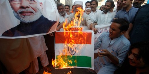 Pakistanis burn a representation of an Indian flag and a poster of Indian Prime Minster Narendra Modi during a protest to express solidarity with people in Kashmir, Peshawar, Pakistan, Aug. 5, 2019 (AP photo by Muhammad Sajjad).