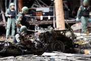 Thai bomb squad officers examine the wreckage of a car after an explosion outside a hotel in Pattani province, southern Thailand, Aug. 24, 2016 (AP photo by Sumeth Panpetch).