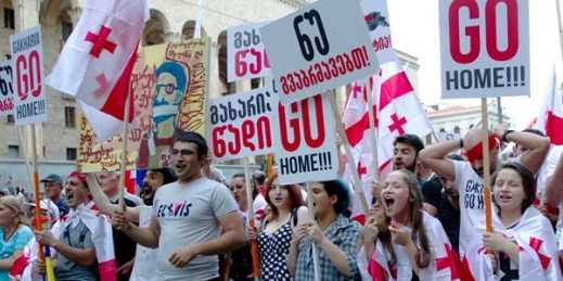 Opposition demonstrators hold Georgian flags and posters reading “Georgian Interior Minister Giorgi Gakharia go home” during a rally in front of the Georgian Parliament’s building in Tbilisi, Georgia, July 6, 2019 (AP photo by Shakh Aivazov).
