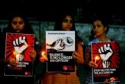 Indian women hold candles and posters during a protest against two recently reported rape cases, in Ahmadabad, India, April 16, 2018 (AP photo by Ajit Solanki).