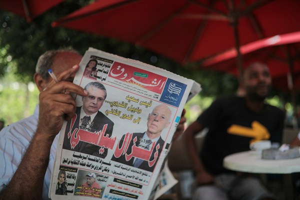 A man reads the Al-Shorouk daily newspaper showing candidates Kais Saied, right, and Nabil Karoui on its front page, a day after the first round of presidential elections, in Tunis, Tunisia, Sept. 16, 2019 (AP photo by Mosa’ab Elshamy).
