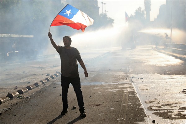 An anti-government protester waves a Chilean flag in Santiago, Oct. 29, 2019 (AP photo by Rodrigo Abd).