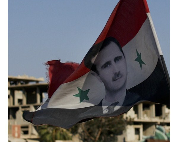 Cover photo: A Syrian national flag with the picture of the President Bashar al-Assad hangs at an army checkpoint in the town of Douma in the eastern Ghouta region outside Damascus, July 15, 2018 (AP photo by Hassan Ammar).