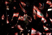 Anti-government protesters wave Lebanese flags and shout slogans against the Lebanese government during a protest in Beirut, Oct. 21, 2019 (AP photo by Hassan Ammar).