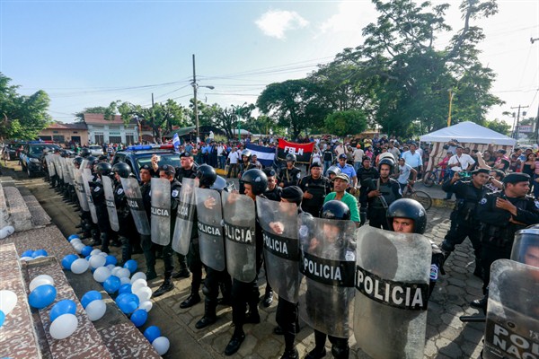 Police form a line outside a church during a demonstration urging the government to free political prisoners, in Masaya, Nicaragua, Aug. 28, 2019 (AP photo by Alfredo Zuniga).