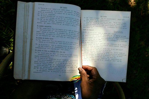 Maka indigenous leader-in-training Tsiweyenki, or Gloria Elizeche in Spanish, handles a copy of the Bible translated into her native language, in Mariano Roque Alonso, Paraguay, April 17, 2019 (AP photo by Jorge Saenz).