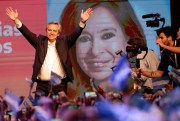 Argentine President-elect Alberto Fernandez waves to supporters, standing in front of an image of his running-mate, Cristina Fernandez de Kirchner, on Election Day in Buenos Aires, Oct. 27, 2019 (AP photo by Daniel Jayo).