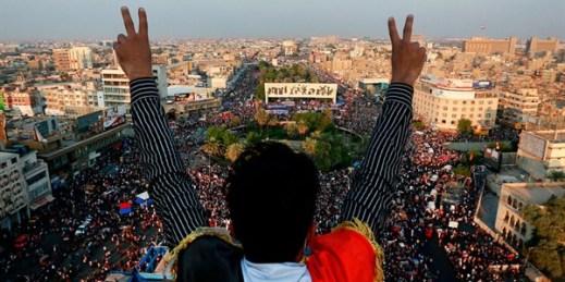 A protester flashes the victory sign overlooking a huge anti-government rally in Tahrir Square, Baghdad, Iraq, Oct. 31, 2019 (AP photo by Hadi Mizban).