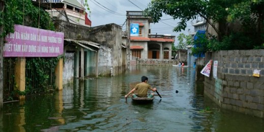 A man paddles a boat through a flooded village in Hanoi, Vietnam, July 31, 2018 (AP photo by Manh Thang).