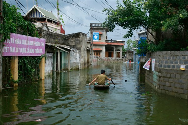 A man paddles a boat through a flooded village in Hanoi, Vietnam, July 31, 2018 (AP photo by Manh Thang).
