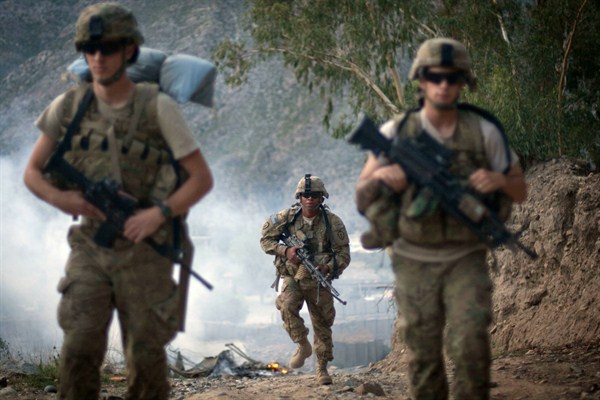 U.S. Army soldiers hike past burning rubbish in Kunar province, Afghanistan, Sept. 10, 2011 (AP photo by David Goldman).
