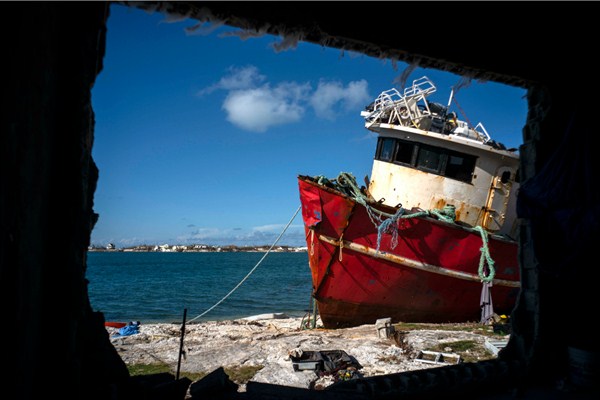 A ship that ran aground during Hurricane Dorian is seen through the broken wall of a house, in Abaco, Bahamas, Sept. 27, 2019 (AP photo by Ramon Espinosa).