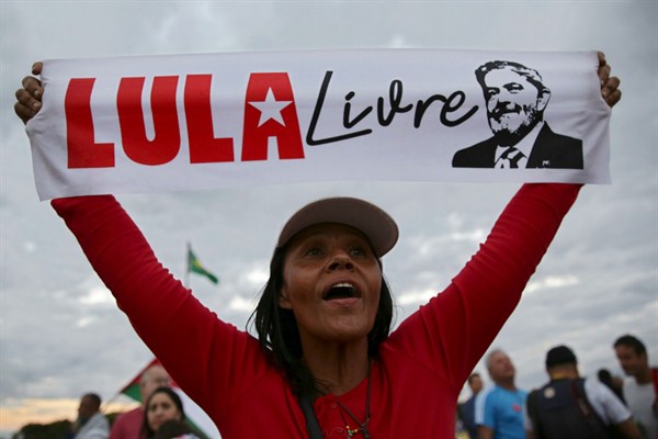 A supporter of former Brazilian President Luiz Inacio Lula da Silva holds a poster that says in Portuguese “Free Lula,” Brasilia, Brazil, June 25, 2019 (AP photo by Eraldo Peres).