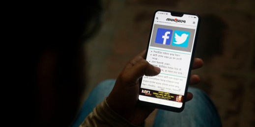 A person reads a news report about Facebook, which shut down a number of fake news sites that were spreading disinformation ahead of national elections, on his mobile phone, Dhaka, Bangladesh, Dec. 20, 2018 (AP photo).