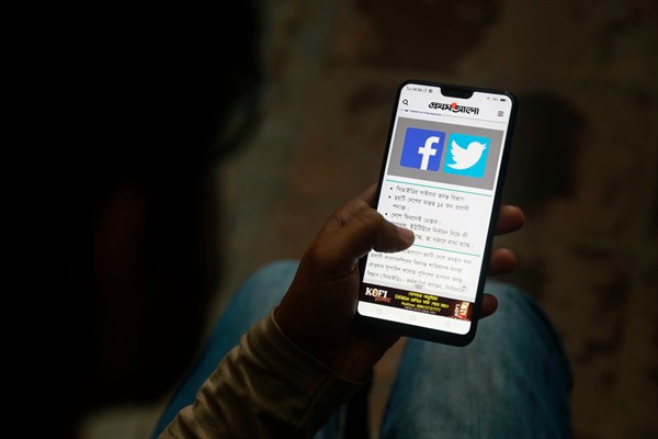 A person reads a news report about Facebook, which shut down a number of fake news sites that were spreading disinformation ahead of national elections, on his mobile phone, Dhaka, Bangladesh, Dec. 20, 2018 (AP photo).