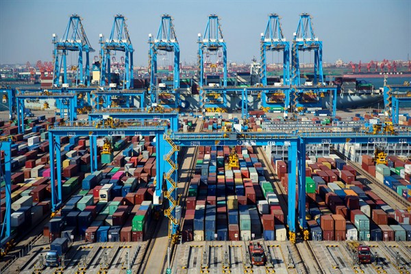 Trucks load containers at the automated container dockyard in Qingdao, Shandong province, China, Nov. 28, 2019 (Chinatopix photo via AP Images).