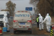 Workers disinfect a passing vehicle after the latest incident of African swine flu outbreak on the outskirts of Beijing, China, Nov. 23, 2018 (AP photo by Ng Han Guan).